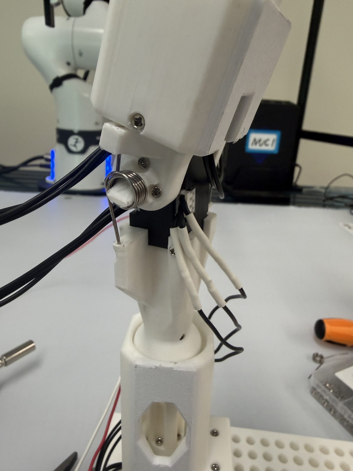 Gravity-compensation torsion spring mounted at a GELLO joint